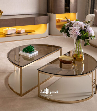 طاولة قهوة بتصميم منحني من الزجاج الملون على إطار معدني مصقول