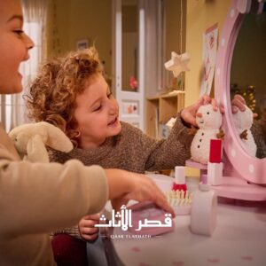 طفلان يستخدمان طاولة التجميل وأدوات اللعب الخشبية